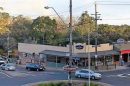 View of Belgrave shopping strip with shops, cars and pedestrians in Victoria.