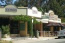 View of a small shopping strip with cafes and shops in Kallista, Victoria.