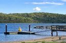 Lysterfield Lake with a wooden jetty and surrounding greenery in Victoria, Australia.