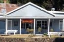 The Destiny Point Cafe is a blue, single-story building with a white roof and outdoor seating.