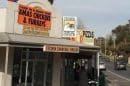 View of Tecoma shopfront with signs for Christmas chicken and turkeys, and pizzas.