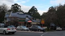 Street scene with cars and a cafe in a wooded area of the Dandenong Ranges.